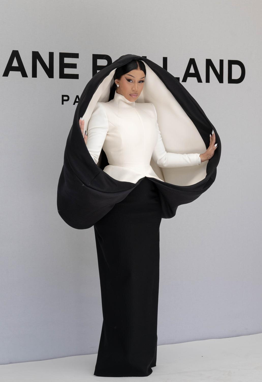 Portrait sur le step and repeat, silhouette sculpturale noire