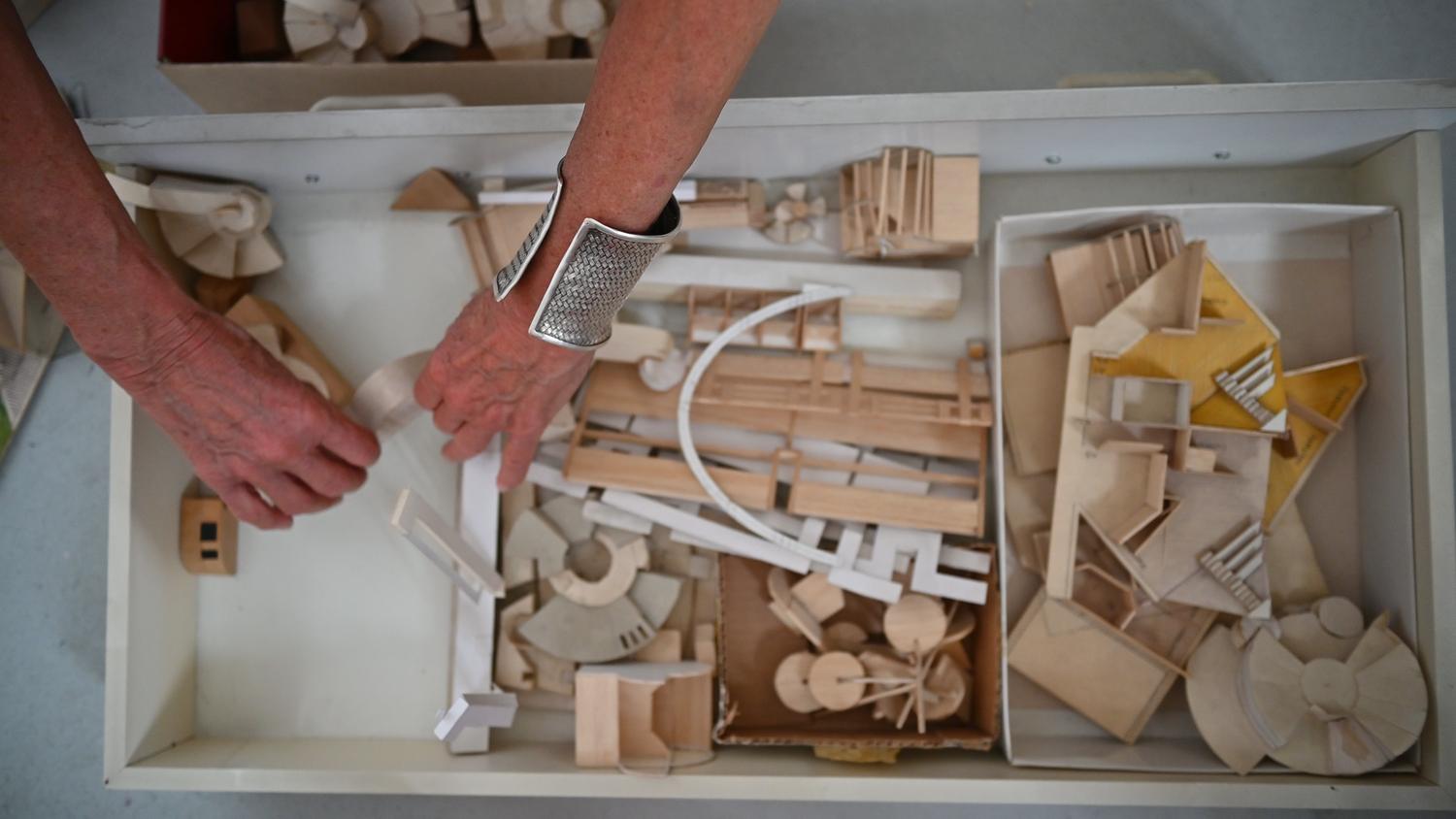Mains triant des maquettes en bois dans un tiroir d'atelier